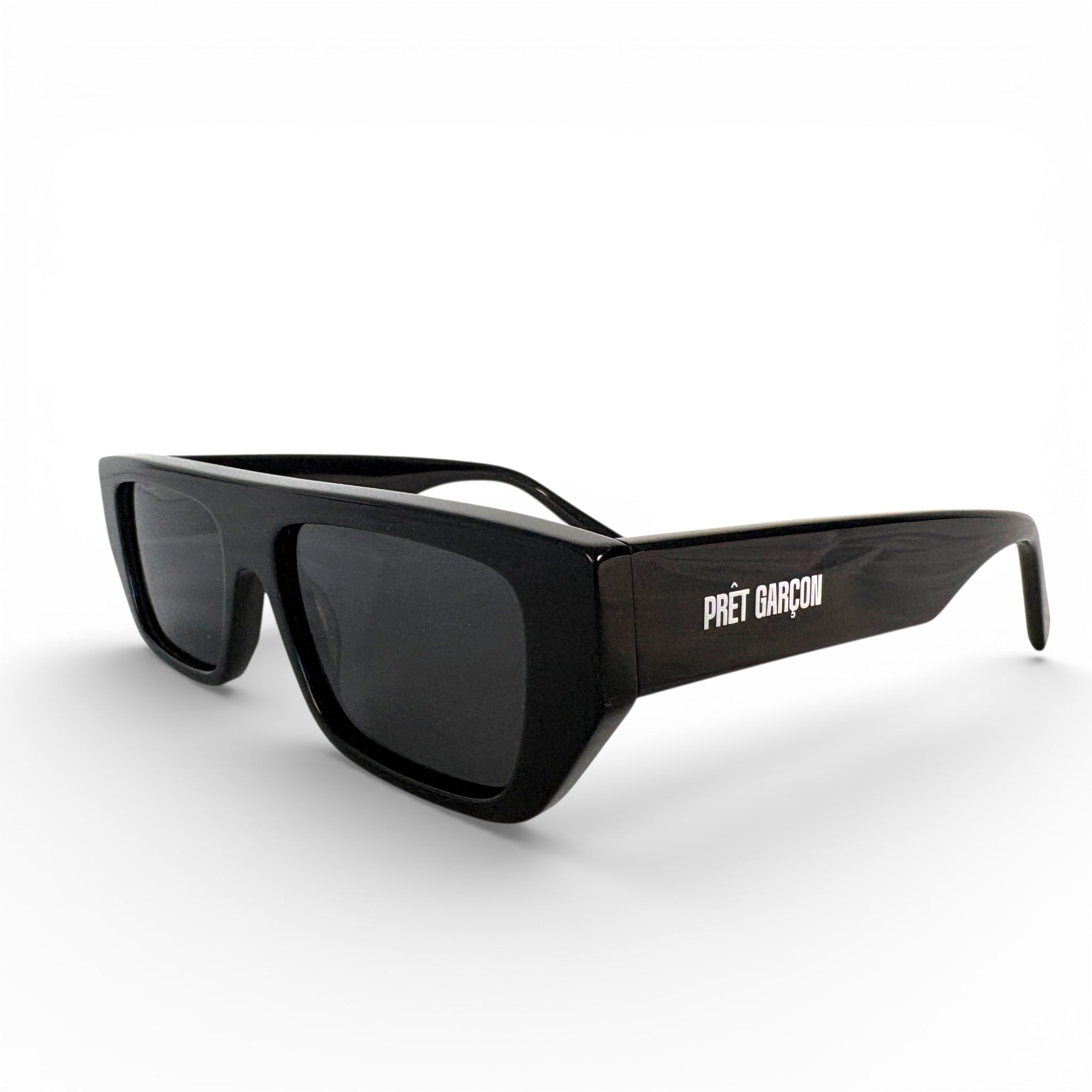 PRÊT GARÇON GODARD black sunglasses, angled side view with logo on temple, minimalist luxury eyewear on white background